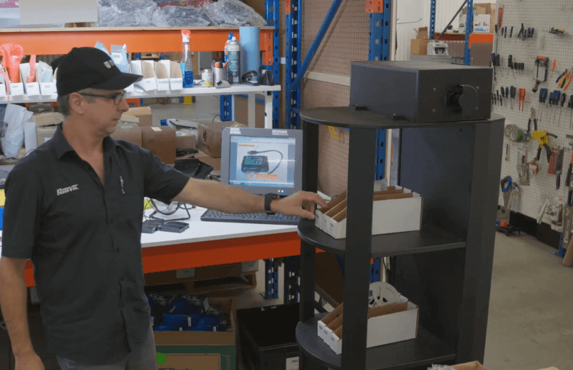Photo of an employee in a factory who goes to look for a room in a storage box.